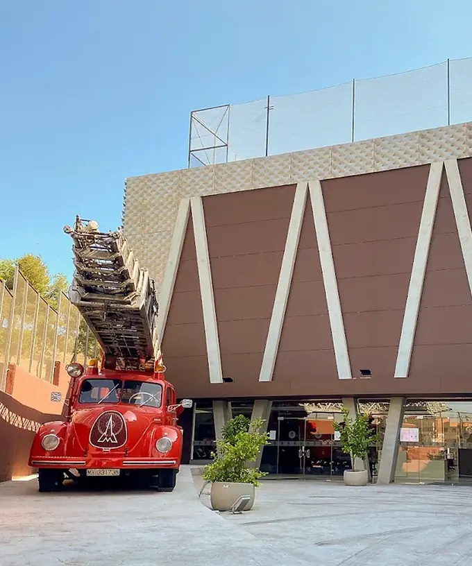Entrada del Museo de Bomberos de Madrid con camión de bomberos clásico exhibido al aire libre.